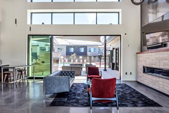 A modern living room with a fireplace and a view of the backyard.